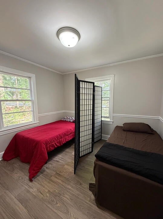 Pasadena Avenue furnished room Pasadena Avenue furnished shared room with two beds, a room divider, and sunny windows