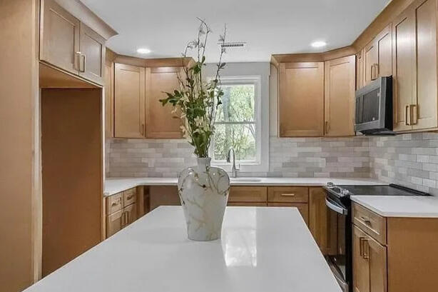 Crestone Drive kitchen Crestone Drive kitchen with an island, wood cabinets, and a tiled backsplash